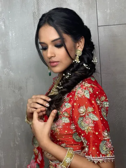 A softer angle of this stunning Mehendi style. The intricate braid and floral details add a touch of romance to the bold makeup.