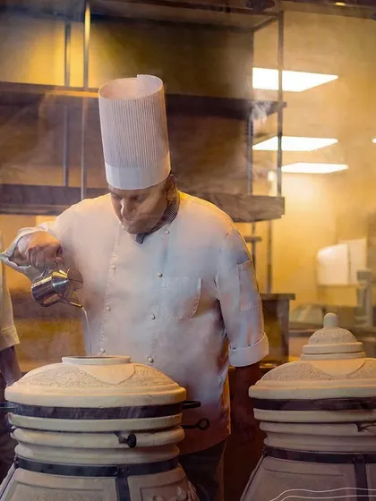 Our chefs working at traditional tandoors, showcasing the authentic cooking methods we use to achieve unparalleled flavor in our Indian dishes.