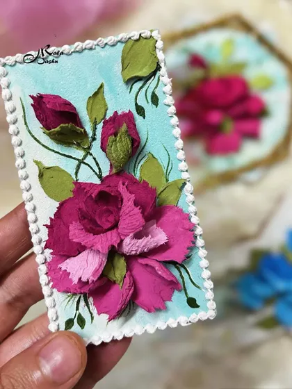 A rectangular fridge magnet featuring a vibrant pink flower and buds on a light blue background.