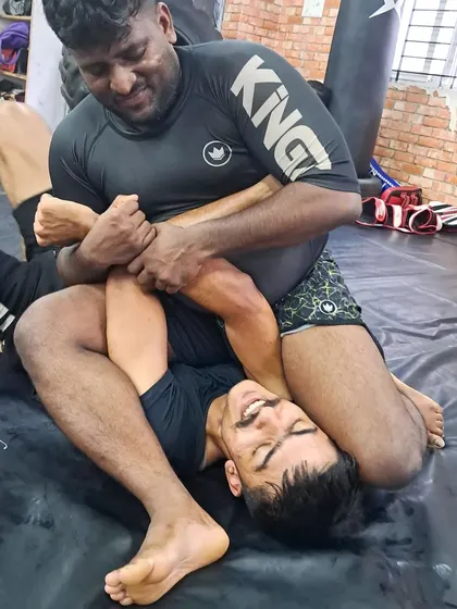 Our coach demonstrating a submission on a smiling student. We train hard, but we also maintain a fun and positive atmosphere.