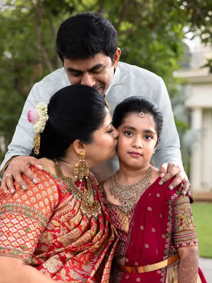 A classic family portrait of a mother, father, and daughter, filled with affection and pride during a traditional milestone event.