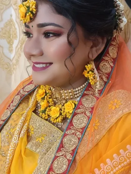 A happy, smiling shot of the Haldi bride, capturing the joy of the occasion. The dewy makeup finish looks fresh and natural.