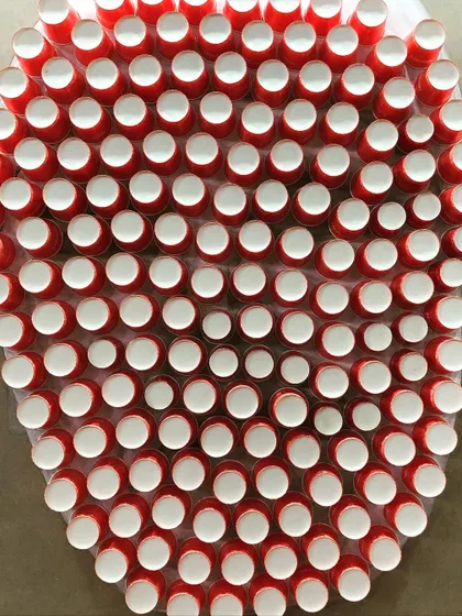 As a tribute to coffee farmers, this portrait was created live at the World Coffee Conference using waste from the Nescafé stall. The face is formed from used paper cups, and the background is a mosaic of empty coffee sachets contributed by visitors, making it a truly collaborative and sustainable piece.
