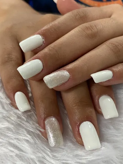 A classic and clean set of white square nails with a subtle silver glitter accent. This timeless look is always in high demand with clients.