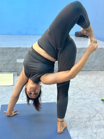 A student in a standing twist and bind, a challenging pose that requires open shoulders and hips.