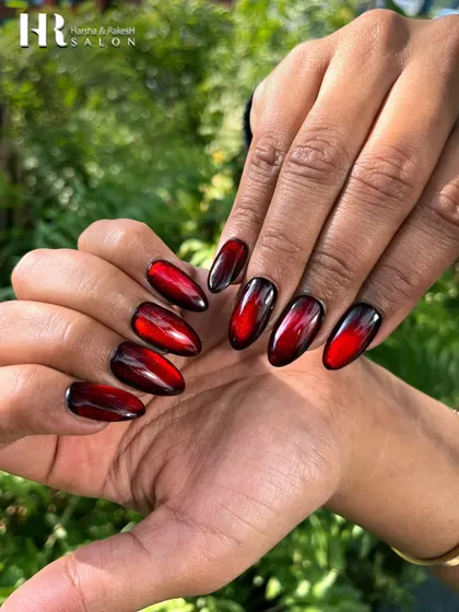 A bold and dramatic ombre design. We blended a vibrant red into a deep black on almond-shaped nails, creating a fiery effect that is both edgy and glamorous.