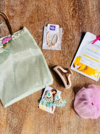 A simple yet beautiful Rakhi gift set for a sister, featuring a net bag, jewelry, and a face mask.