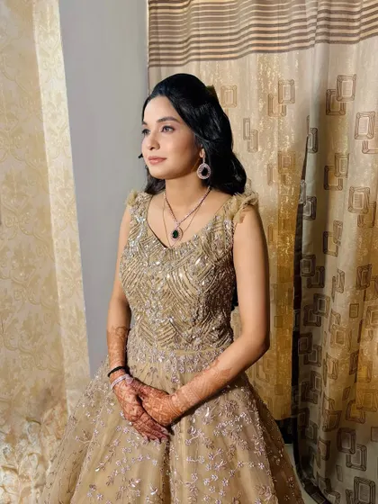 A poised and elegant look for an engagement party. The makeup features defined eyes and a neutral lip, letting her natural beauty and the stunning gown shine.