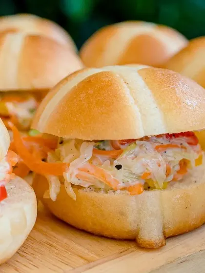 Mini hot cross buns filled with a fresh and crunchy coleslaw, a perfect bite-sized sandwich.
