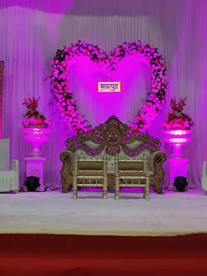A popular choice for engagements is this heart-shaped floral arch. Here, I've used it as the central backdrop, framed by decorative panels and lit with pink lights to create a romantic atmosphere.