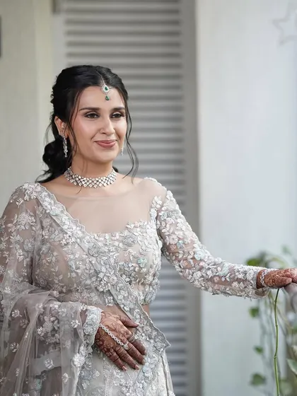 This bride looks absolutely radiant in her intricately embroidered pastel lehenga. The makeup is kept soft and glowing to let the outfit's details shine.