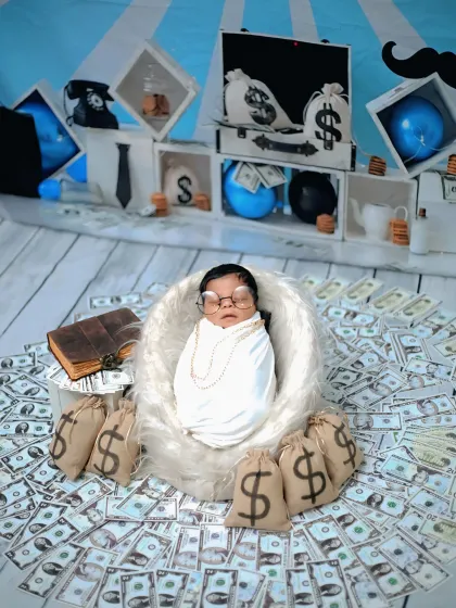 The 'Boss Baby' has arrived. This playful theme features a newborn surrounded by prop money and bags, creating a fun and memorable photo that showcases a lot of personality.