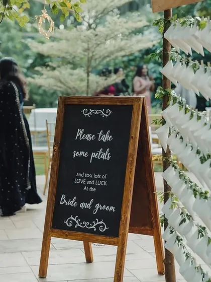 A creative way to guide guests to their seats. We designed these charming paper cones filled with petals, each with a personalized tag indicating the guest's name and their table, which was named after a city the couple had traveled to together.