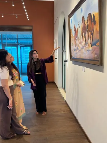 A visitor at the 'Ephemeral Dreams' exhibition, learning about the artist's process and inspiration.