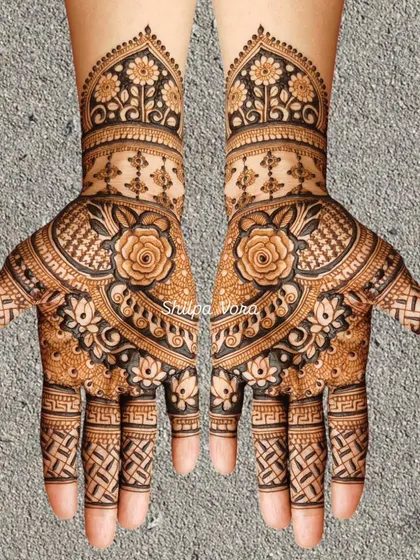 A symmetrical floral design with shaded roses and a unique woven pattern on the fingers.