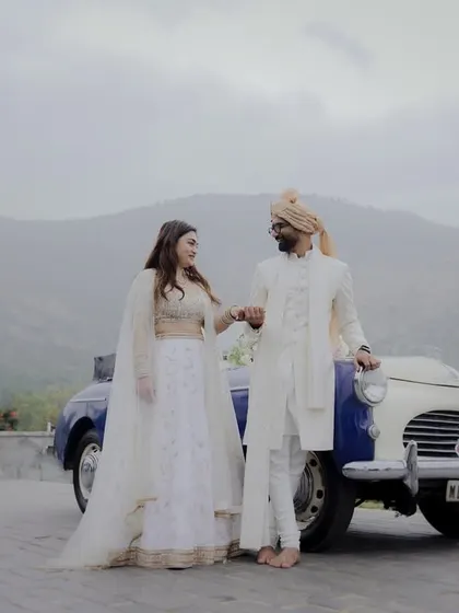 A couple poses with a vintage car, adding a touch of classic elegance to their wedding day portraits.