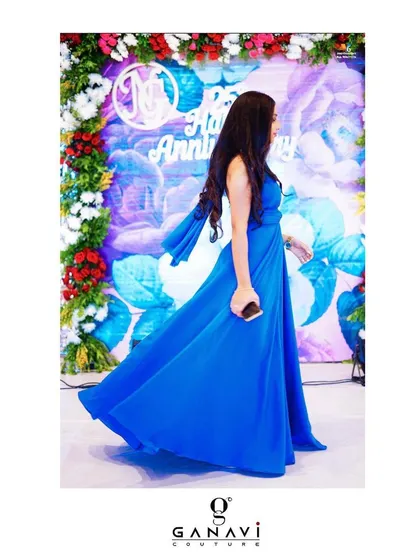 A client breaking the norms in a classic drape gown in a stunning shade of royal blue. The flowing fabric and elegant halter drape create a timeless and sophisticated look.