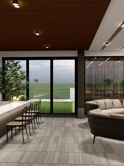 The interior of the Punjabi Bagh terrace project, featuring a lounge and a full bar. The sliding glass doors open completely to merge the indoor space with the outdoor deck.