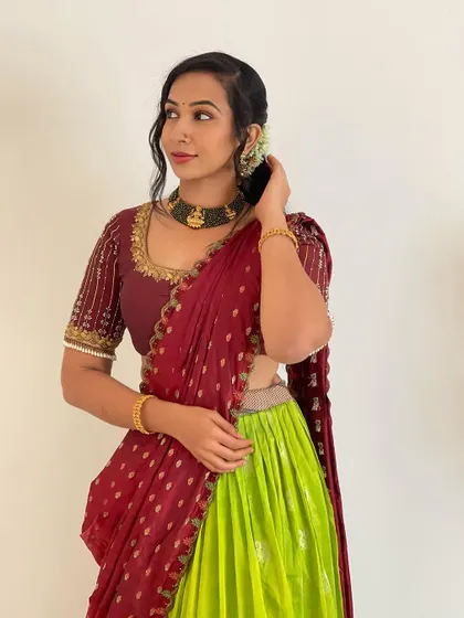 The fine details of the outfit, from the hairstyle to the jewelry, complete the ethnic look. Our rental half saree provides the perfect canvas for your styling.