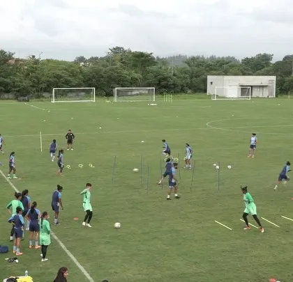 A wide view of a team training session on the pitch. Organizing and conducting drills for a large group requires careful planning to ensure every athlete is engaged and working towards the session's goals, whether it's speed, agility, or endurance.