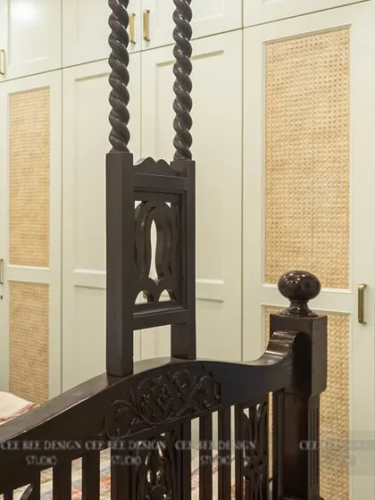 A restored heritage four-poster bed in a room with modern rattan-paneled wardrobes.