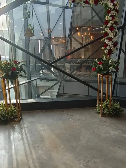 A closer look at the floral arrangements on tall stands, placed against the modern glass architecture of the office building. This shows how I adapt my decor to different interior styles.