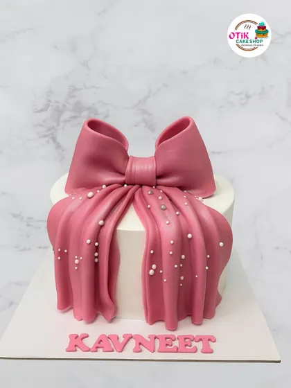 This cake is all about making a statement with a bold pink fondant drape and bow. The pearl-like sprinkles add a touch of glamour, making it perfect for a fashion-forward celebration.