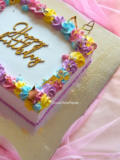 A close-up of the colourful piped border on the unicorn cake.