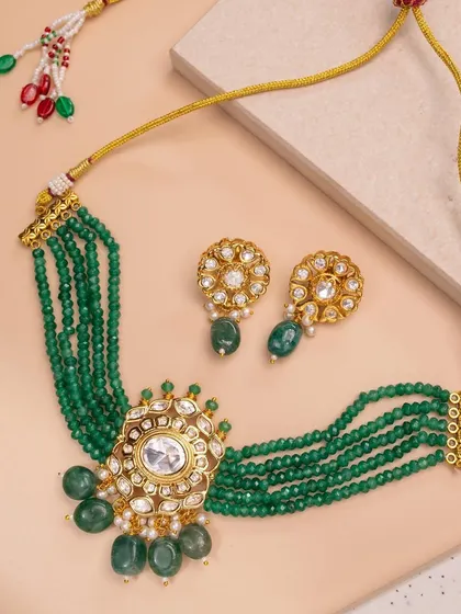 A recent jewelry shoot featuring a gorgeous green beaded choker set. The soft, neutral background allows the vibrant color and intricate kundan work of the jewelry to be the main focus.