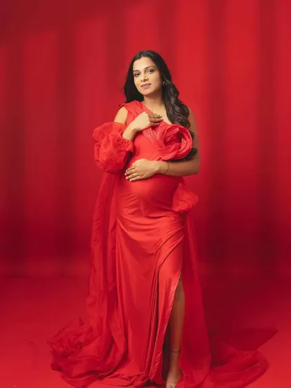 Bold, beautiful, and blooming. This vibrant red gown with a floral shoulder detail makes a powerful and passionate statement.