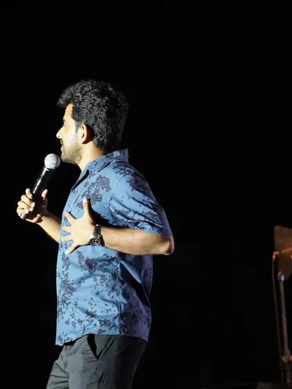 A side profile of Naveen Richard, capturing a moment of storytelling during his act.