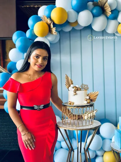Posing by the cake table at a chic blue, white, and yellow themed birthday party.