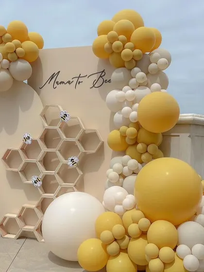 A closer look at the "Mama to Bee" setup, showing the beautiful balloon arch and the elegant script on the backdrop. It's a sophisticated and sweet theme for a baby shower.