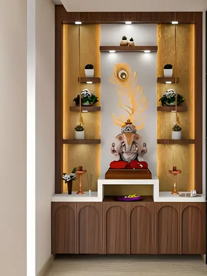 Another elegant pooja unit design featuring a large peacock feather. The warm wood tones, white countertop, and soft backlighting create a peaceful and inviting spiritual corner.