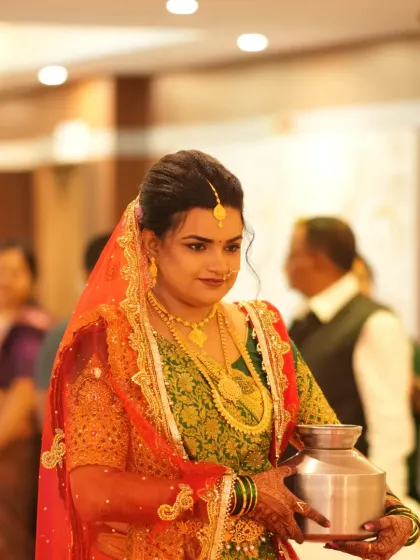 Here the bride is captured during a wedding ritual. Her traditional makeup, including the bindi and nath, remains flawless and elegant.