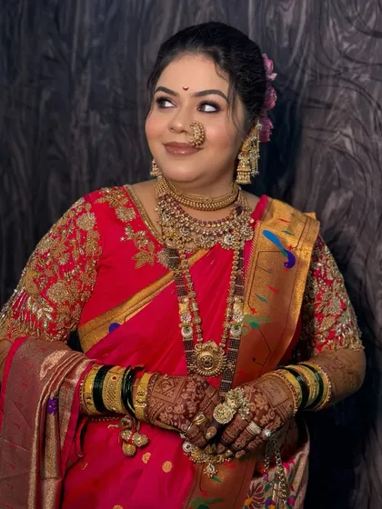 A close-up portrait of the bride, showing her soft makeup and traditional nath.