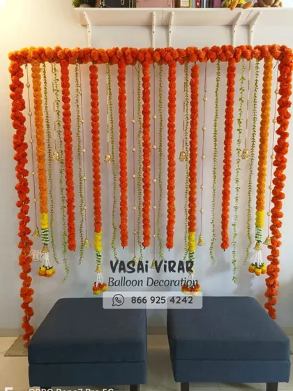 Sometimes, simple is the most beautiful. This is a traditional and elegant backdrop for a home-based naming ceremony, created with strings of fresh orange and yellow marigold flowers. It's perfect for photos and adds a classic touch.