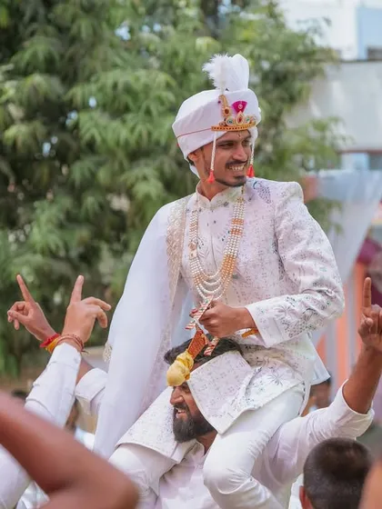 The groom's energetic entry to the wedding venue, carried on the shoulders of his friends and family.