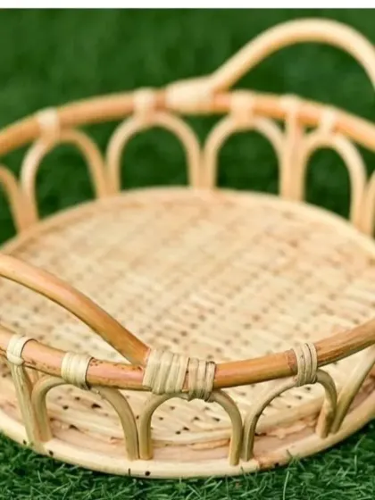 This decorative round tray is handcrafted from cane and rattan, featuring an open, arched design along the sides. It's perfect for serving, creating gift hampers, or as a beautiful centerpiece on your dining table.