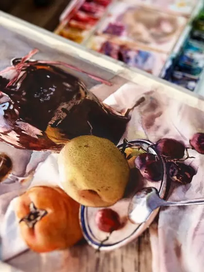 The still life with the pear and persimmon, shown from an angle on my easel. This view reveals the texture of the paper and the richness of the watercolor pigments.