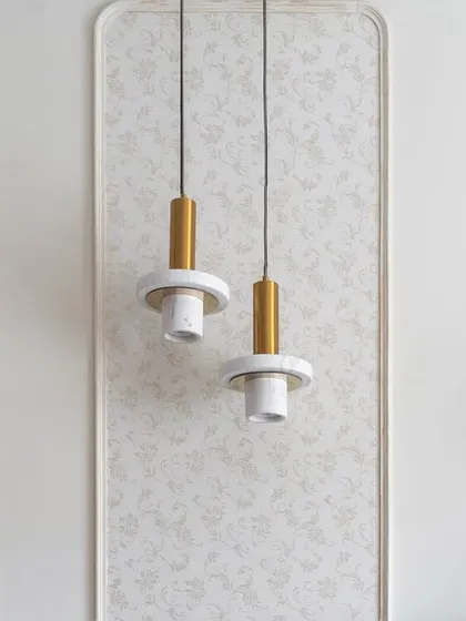 Detail of the pendant lights and wall treatment in the 'Flux Abode' master bedroom. The floral wallpaper inside the rounded rectangular moldings adds subtle texture.