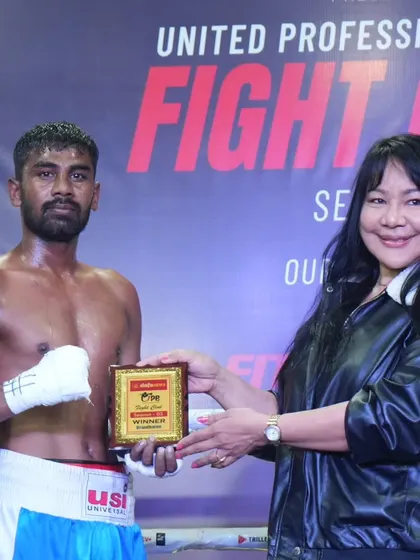 A victorious fighter being awarded his prize. We celebrate every win as a step forward in their professional career.