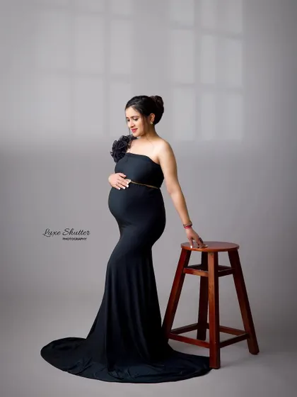 A simple, elegant pose in a classic black gown. The addition of a stool adds a point of interest and allows for a graceful, statuesque posture.