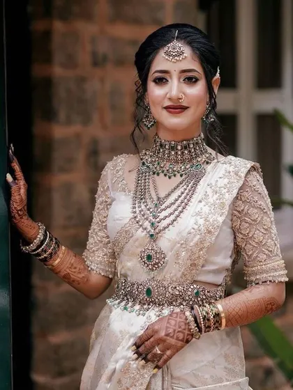 This bride's look is all about timeless elegance. Her off-white saree with a custom embroidered blouse is a classic choice for any bride.