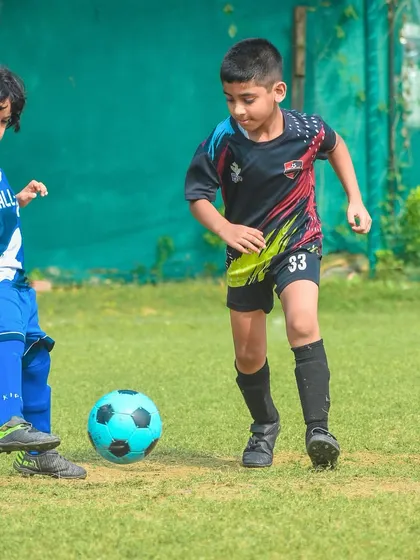 Two of the youngest players showing off their dribbling skills with a brightly colored ball.