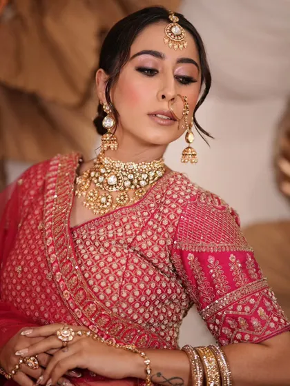 A complete bridal look featuring a heavy, gold-plated Kundan necklace, haath phool, and maang tikka, all available for rent.
