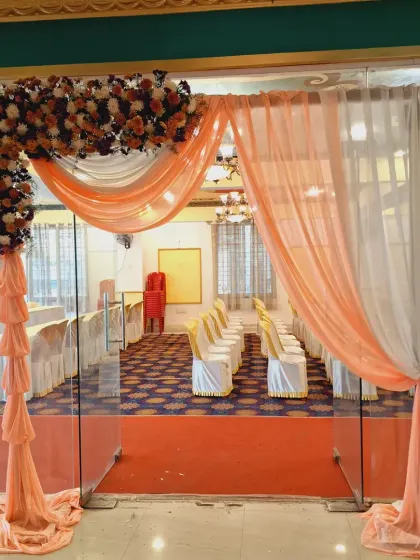 A simple and elegant entrance arch for a hall. I used a combination of peach and white drapes with a floral arrangement on the corner to create a welcoming passage for guests.