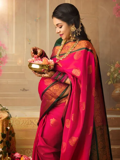 A serene portrait of an expecting mother holding a pot of flowers. Her traditional pink saree and the artistic setting create a beautiful and symbolic image of life and fertility.