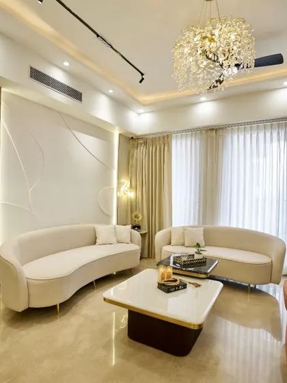 This living room at Apex D’Rio is all about soft curves and a calming, neutral palette. The custom wall paneling adds texture and interest, while the crystal chandelier brings a touch of glamour.