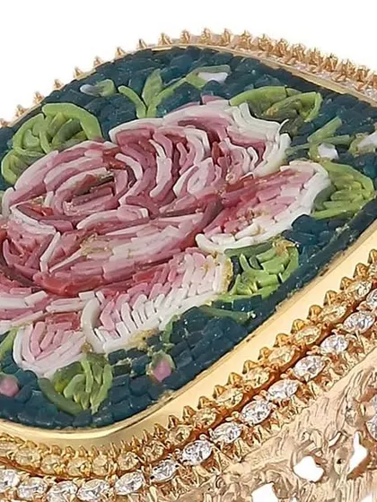 An angled view of the micromosaic rose ring, showing the three-dimensional quality of the textured gold band and the intricate detail of the floral mosaic work.
